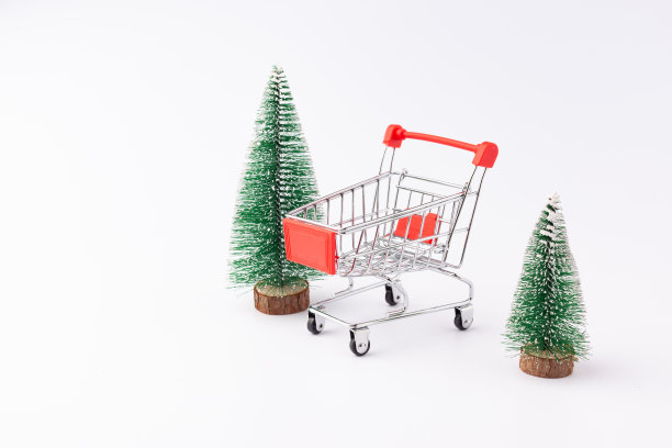 两棵圣诞树和一辆超市手推车图片下载