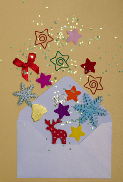 黄色背景的信封里的圣诞乐趣。图片下载