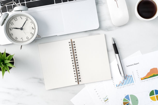 办公桌边，大理石白色背景上的空白笔记本，报告和闹钟。图片下载