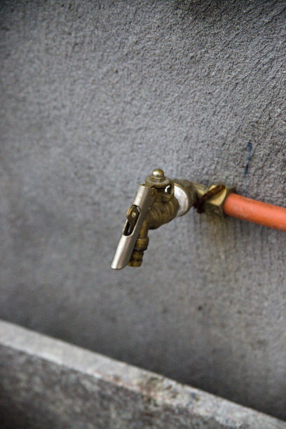 灰色水泥墙上的水龙头图片下载