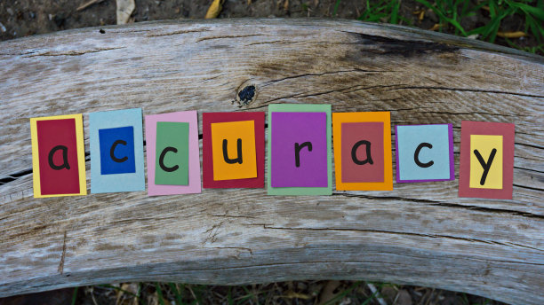 准确的文字写在彩色的便利贴木质背景上。图片下载