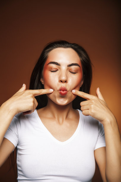 漂亮女孩开心摆姿势:褐发背景，生活方式人的概念图片下载