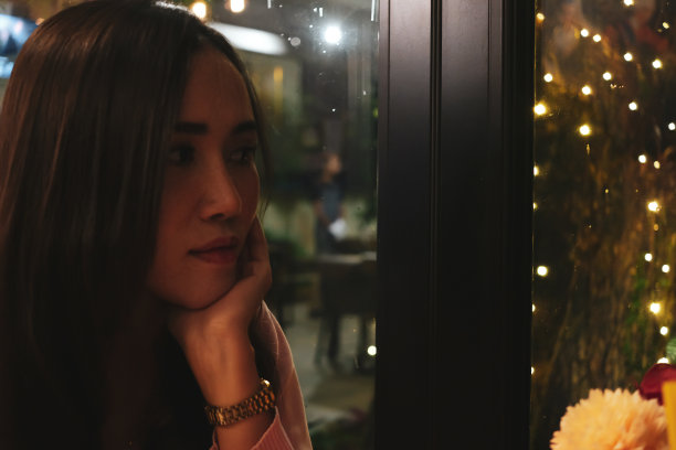 圣诞节那天，年轻女子望着窗外回忆过去的记忆图片下载