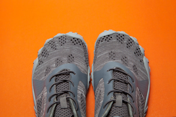 运动灰色运动鞋孤立在橙色的背景图片下载