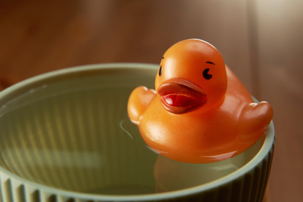 玩具黄色小鸭子在碗里的特写图片下载