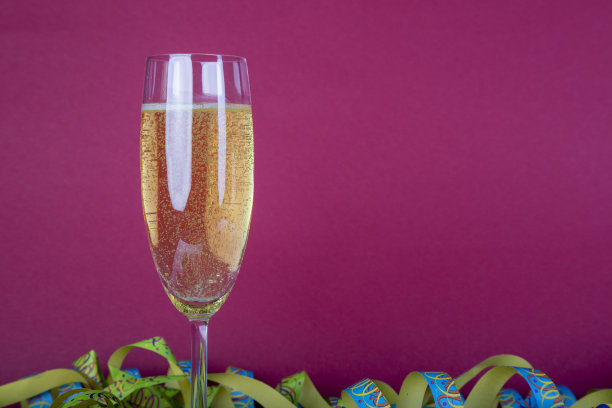 一杯起泡的葡萄酒，一个流光作为背景和一个红色的背景图片下载