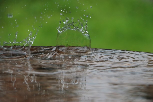 雨滴落在花园里的水坑里，落在潮湿的桌子上图片下载