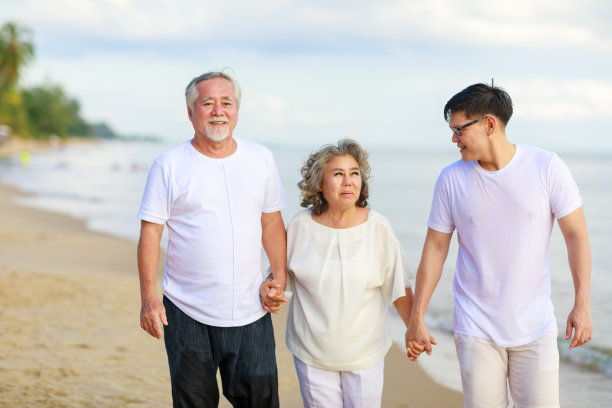 幸福的家庭漫步在沙滩上放松。图片下载