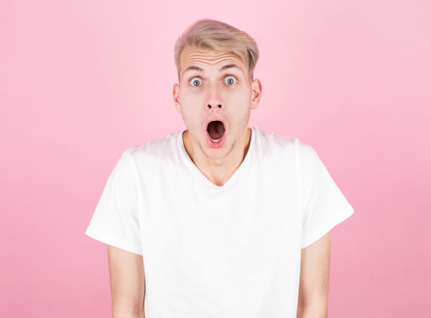 震惊有吸引力的时尚男子保持手在头顶粉红色的背景。惊讶的概念图片下载