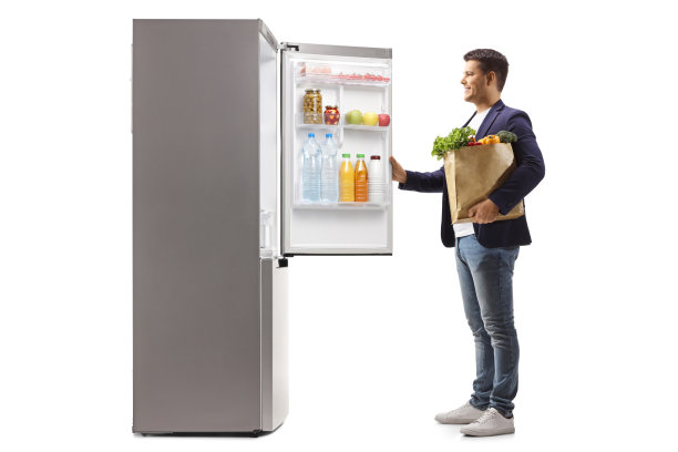 拿着购物袋打开冰箱的男人图片下载