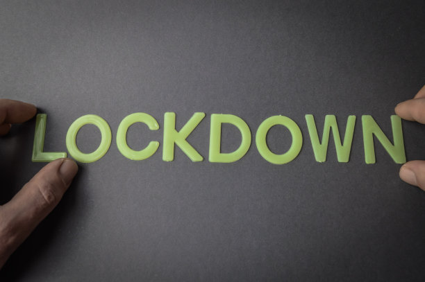 人们的手指在灰色的纸上用塑料字母写着“锁定”，概念图片下载