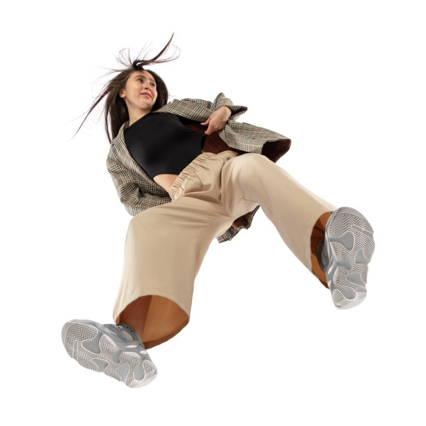 年轻时尚的女子在现代街头风格的服装孤立在白色背景，从底部拍摄图片下载