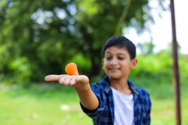 可爱的印度小孩玩拉图，Bhovra或Bambaram是一种传统的用线扔陀螺，主要在印度玩图片下载
