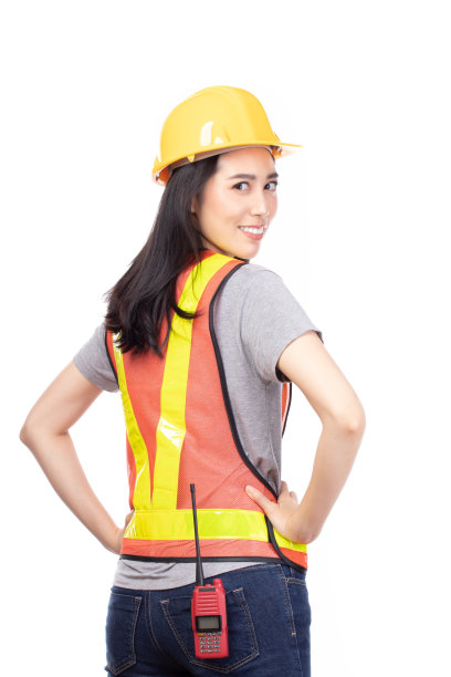 美丽年轻的亚洲建筑女工人在黄色头盔和反光背心摆孤立的白色背景。图片下载