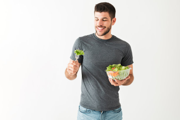 健康的年轻人用叉子吃绿色沙拉图片下载