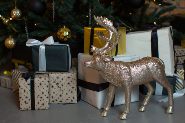 一只铜色的银色鹿，映衬着装有新年礼物和圣诞树的彩色盒子图片下载
