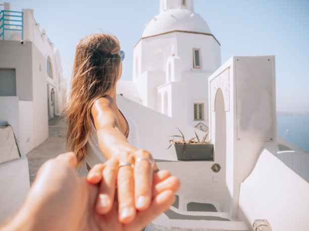 在圣托里尼的街道上牵手的夫妇图片下载