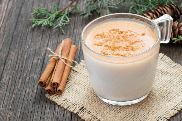 一杯土耳其传统牛奶热饮，配肉桂粉，放在质朴的老式木桌上图片下载