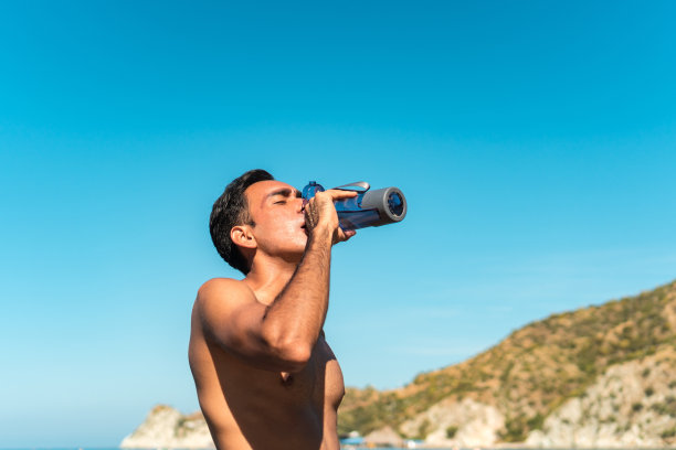 夏天，跑步者在海滩上休息、喝水。图片下载