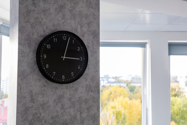 在一个明亮的房间里，墙上挂着一个黑色的大钟图片下载