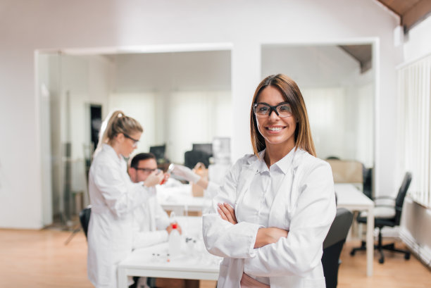 女性研究者的肖像。同事在后台。图片下载