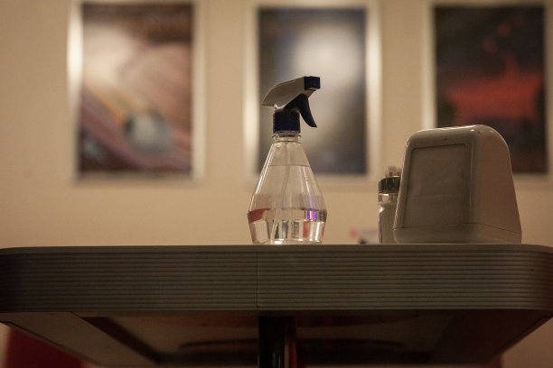 放置在餐桌或餐厅餐饮设施上的装有酒精类消毒液的喷雾器，在冠状病毒感染的危机期间用于洗手和清洗表面。图片下载