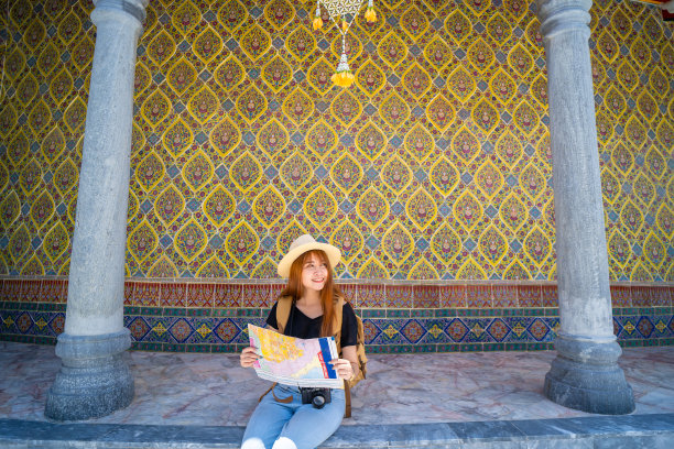 可爱的亚洲女人背着背包休息，看着地图图片下载