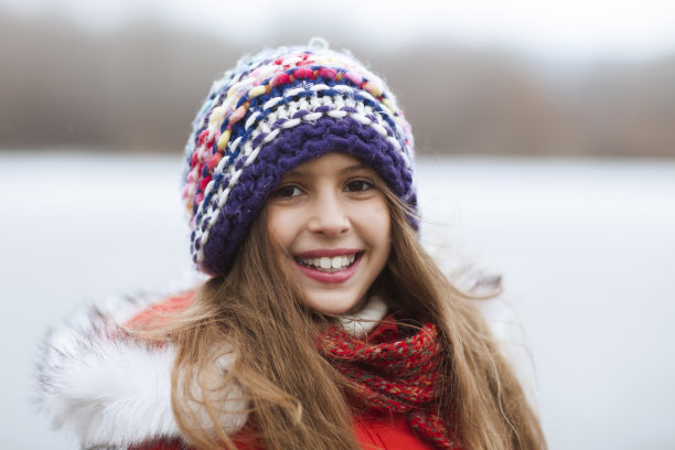 肖像微笑的小女孩走在寒冷的冬天。活跃的寒假概念。他为错过而高兴。图片下载