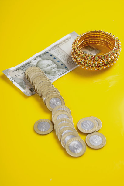 新印度500卢比纸币，硬币和黄金珠宝上的黄色背景图片下载