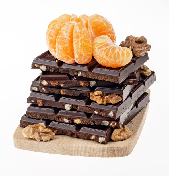 橘子、巧克力、核桃放在小木砧板上图片下载
