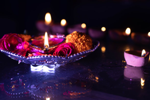 美丽的火焰从发光的陶土灯Diya或深黑色背景与反射在迪帕瓦里新年庆祝活动中拍摄在黑暗的夜晚在节日庆祝活动与背景散景图片下载