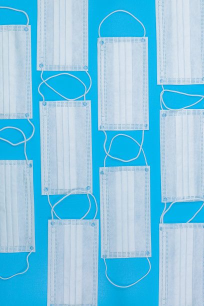 冠状病毒COVID-19大流行。防护冠状病毒的抗病毒医用口罩。手术防护面具。蓝色背景上的医用呼吸绷带。隔离待在家里图片下载