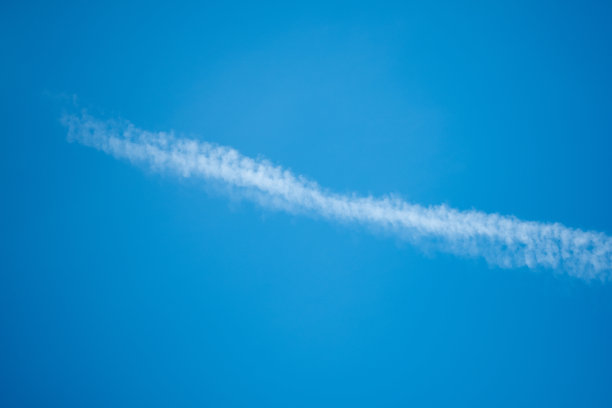 蓝天上的云朵和喷气式飞机的尾迹。自然背景图片下载