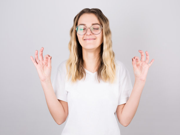 年轻迷人的女人在莲花的位置沉思在白色的背景。图片下载