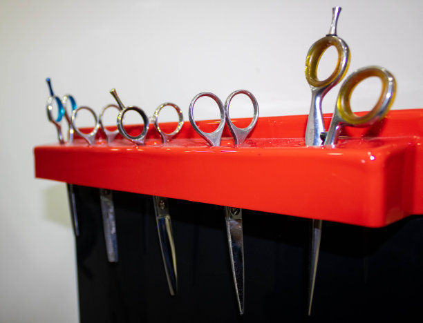 美容院的一把专业理发剪刀挂在一个红色的塑料卡片上图片下载