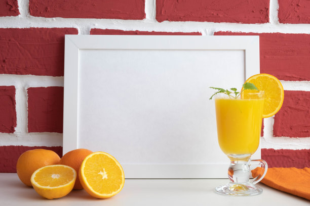 在一个相框后面，在一堵砖墙后面，桌子上放着一个玻璃杯，里面装着新鲜榨好的橙汁图片下载