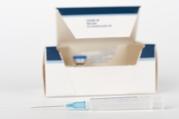 医学概念，带针的注射器，小瓶和带Covid-19疫苗的纸盒图片下载