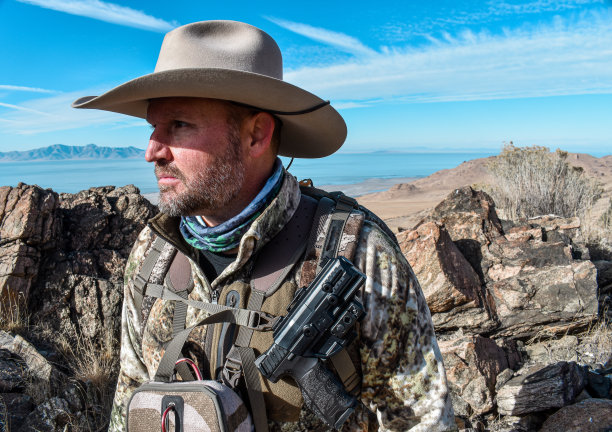 迷彩猎人与牛仔帽迷彩手枪双筒望远镜图片下载