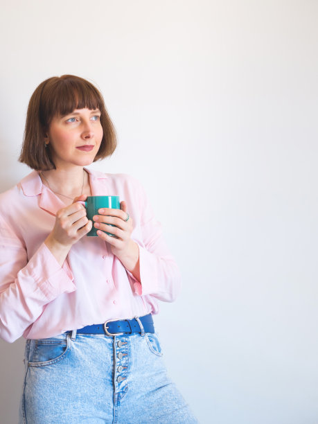 年轻女子微笑着喝着咖啡图片下载