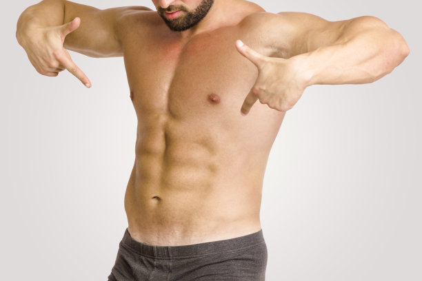 肌肉男用手指指着腹部肌肉图片下载