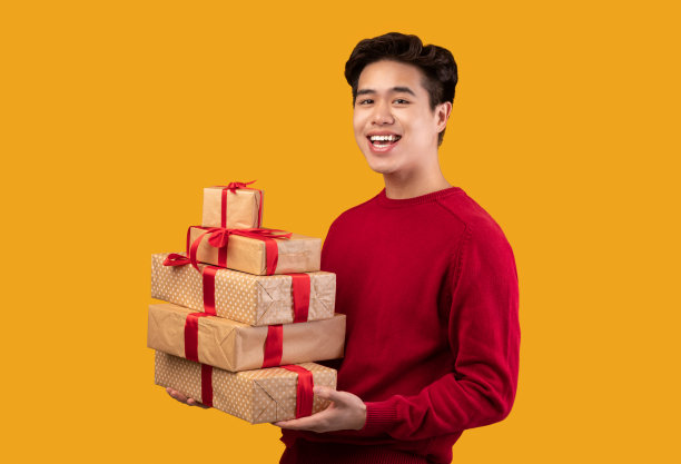 快乐的亚洲年轻人拿着一堆礼物盒图片下载