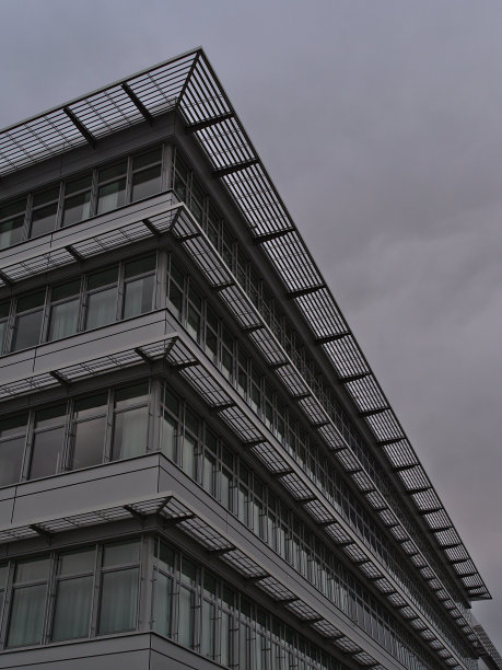 位于商业公园的现代办公建筑的低角度立面，带有玻璃窗户和金属元素。图片下载