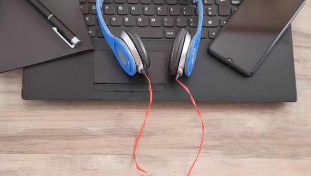 耳机，笔，笔记本键盘上的智能手机。图片下载