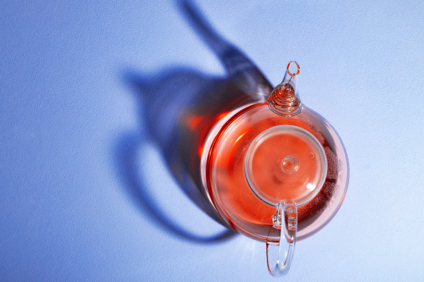 玻璃茶壶与水果茶在蓝色的背景图片下载