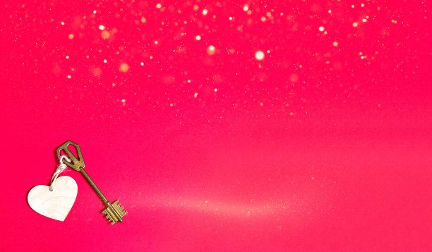 红色背景上有心形木牌的金钥匙。情人节，爱情宣言，拷贝空间。开放,封闭的感觉。甜蜜的家，房地产图片下载