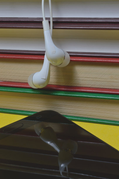 黄色背景的耳机和智能手机。图片下载