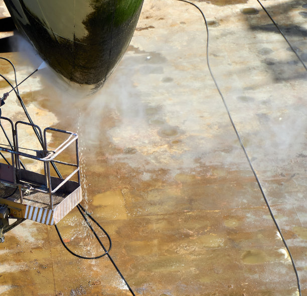 一个工人在船坞里清洗船首图片下载