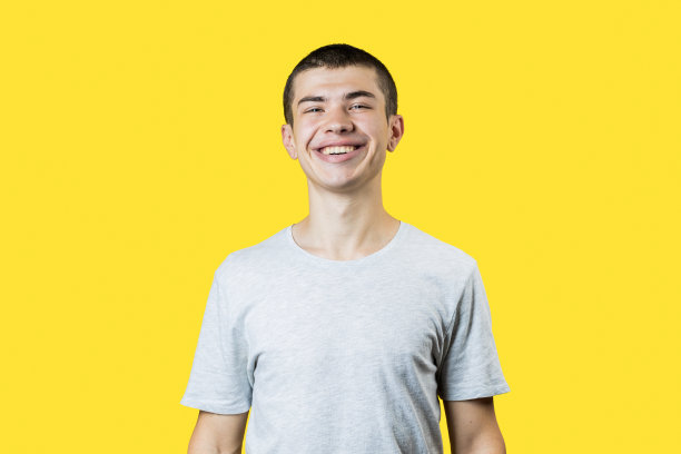 快乐微笑的白人20岁男人在黄色的背景。轻便的衣服。副本的空间。影棚拍摄图片下载