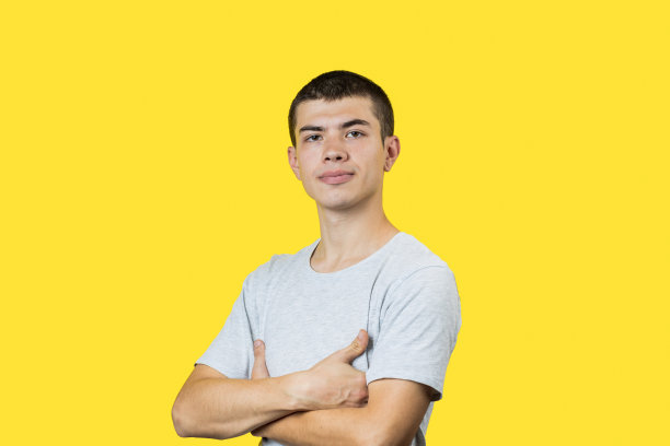 快乐微笑的白人20岁男人在黄色的背景。轻便的衣服。副本的空间。影棚拍摄图片下载