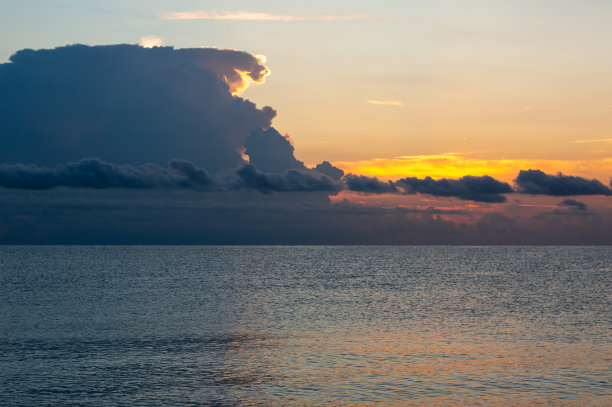 日落时海面上有戏剧性云彩的地平线图片下载